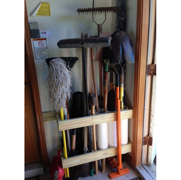 DIY garden tool rack made with PVC pipe and wood