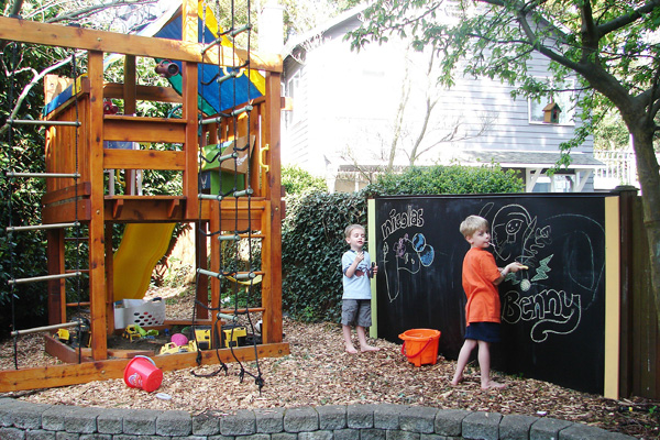 Outdoor space with kid-friendly playhouse and DIY chalkboard
