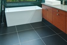 Blue-green bathroom with large floor tiles and minimal grout