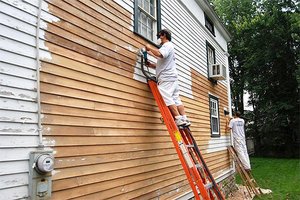 Scraping old paint from a home's exterior
