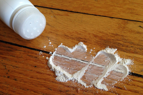 Fixing a squeaky wood floor by sprinkling talc