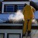 Man steaming away ice dam from roof