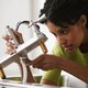 Woman preparing home for sale by fixing faucet