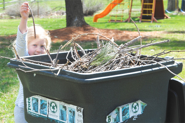 Child collecting sticks in yard