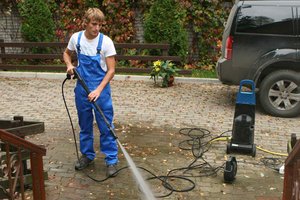 Man cleaning a patio with a power washer