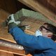 Man installing rigid insulation in an attic