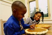 Child sticking his finger in a pumpkin pie